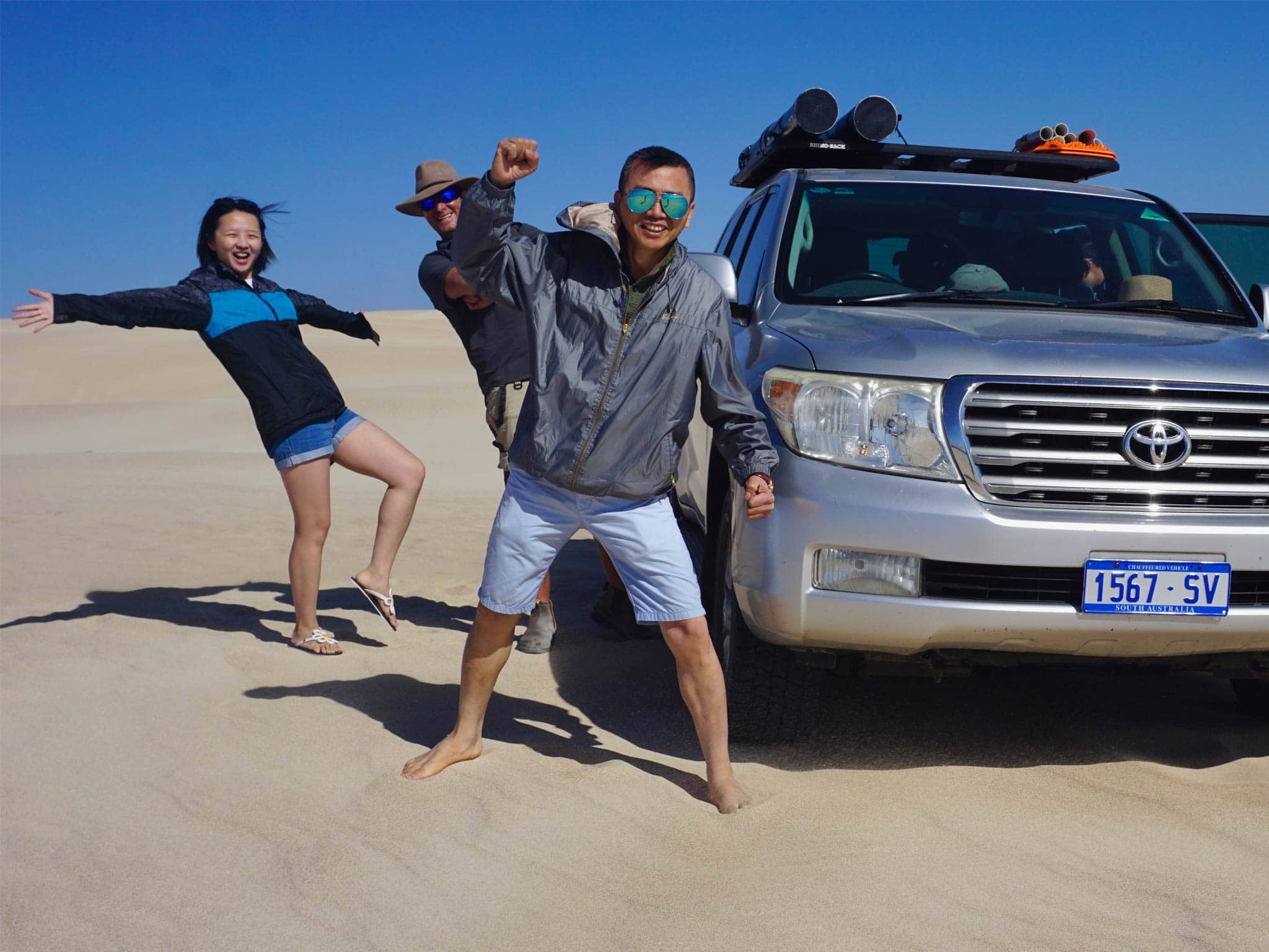 tourists on a sandhill with the car